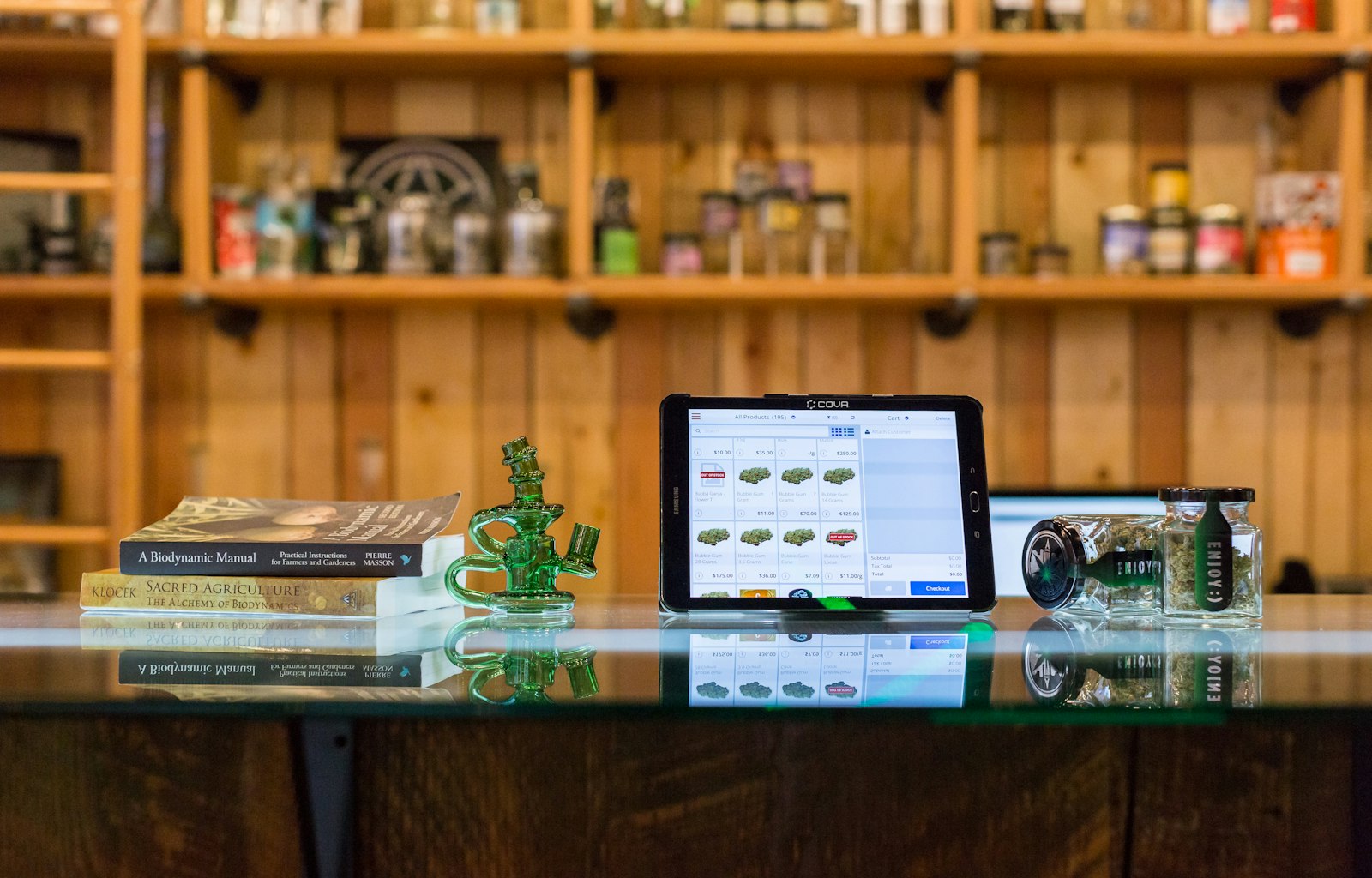 A tablet showing a shop website, standing on a wooden shop counter