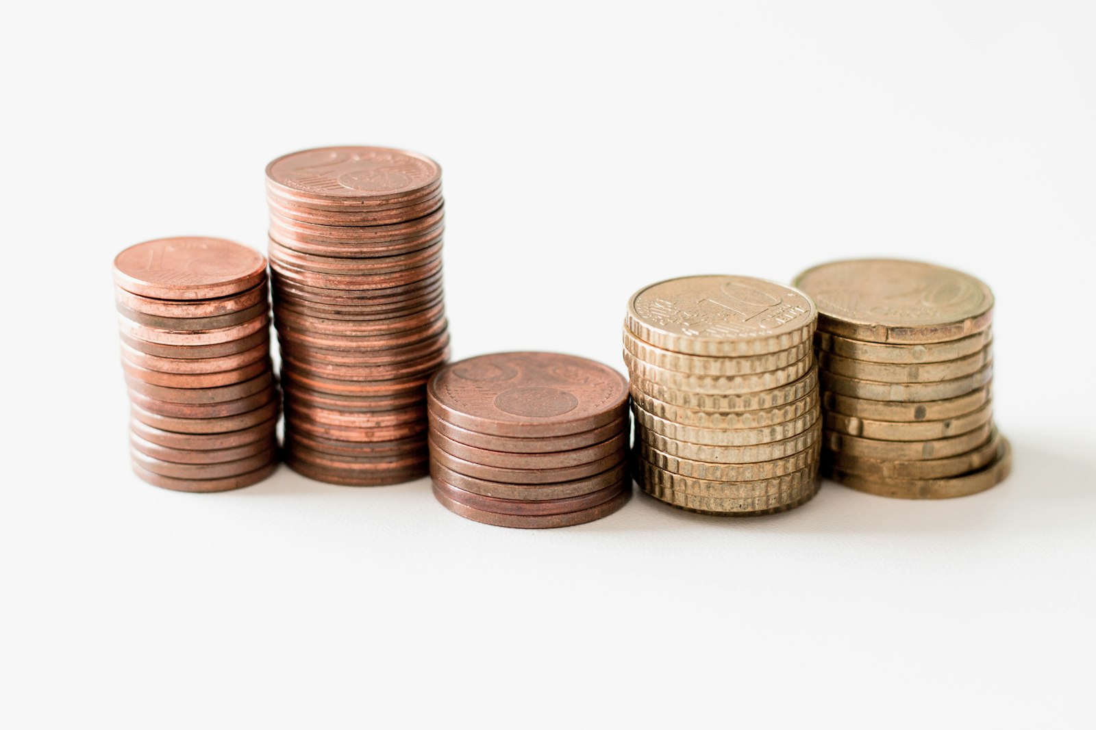 Small stacks of copper and silver coins on a white table