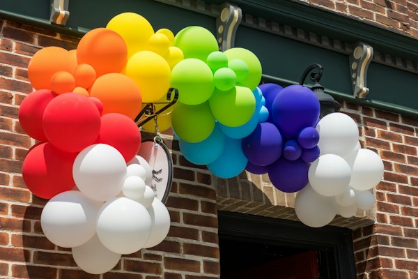 A rainbow balloon arch outside a building